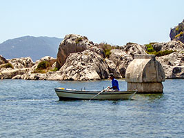 Rowing boat and Lycian sarcophagus popping up from the water